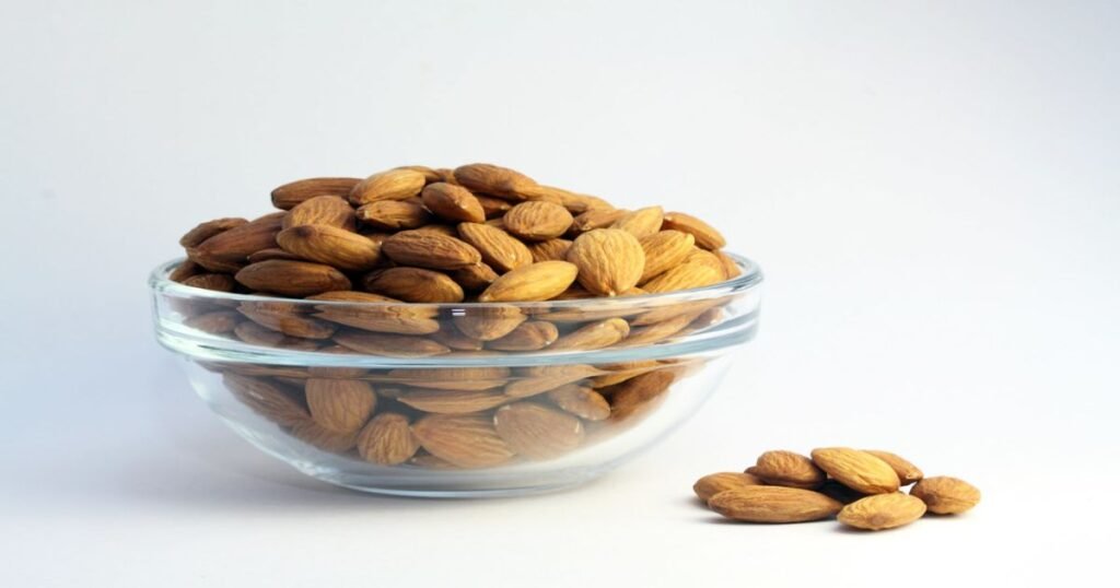 A handful of raw almonds on a bowl.